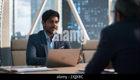 Erfolgreiche indische Geschäftsleute halten eine Bürositzung ab, verhandeln und sprechen über finanzielle Chancen. Geschäftsberater mit Laptop, Gespräch mit einem Kunden im Konferenzraum Stockfoto