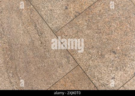 Nahaufnahme des Gehwegs mit Marmorfliesen. Diagonal angeordnete Lücken zwischen den Fliesen. Cremige beige bis braune Farbe. Stockfoto
