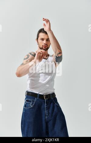 Ein gutaussehender Kaukasier in einem trendigen weißen Hemd und einer blauen Jeans. Stockfoto