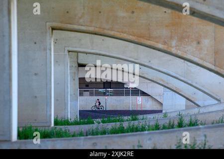 Wolmirstedt, Deutschland. Juli 2024. Ein Radfahrer fährt unter der Kanalbrücke auf der Elbe. Die Kanalbrücke ist insgesamt 918 Meter lang. Sie führt den Schiffsverkehr vom Mittellandkanal über die Elbe und ist die längste Kanalbrücke der Welt. Das Bauwerk ist Teil des Magdeburger Wasserstraßenkreuzes. Rund 68.000 Kubikmeter Stahlbeton wurden für die Brücke verwendet, 10.000 Tonnen Stahl für die Flussbrücke und 14.000 Tonnen Stahl für die Vorlandbrücke. Quelle: Klaus-Dietmar Gabbert/dpa/ZB/dpa/Alamy Live News Stockfoto