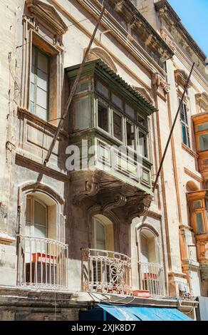 Ein historisches Steingebäude mit leuchtenden blauen Türen und Fenstern, das traditionelle Architektur und urbanes Erbe an einem sonnigen Tag zeigt. Stockfoto