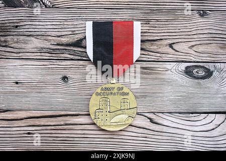 KIEW, UKRAINE - Medaille der US-Armee der Besatzung am 10. JULI 2024. US-Militärmedaille mit Band und Stift. Handgemachte Papierkopffiguren aus nächster Nähe Stockfoto