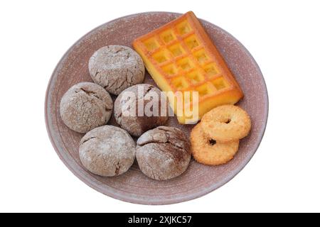 Verschiedene Kuchen und Waffeln in Keramikplatte isoliert auf weißem Hintergrund. Goldener romantischer Keks. Stockfoto