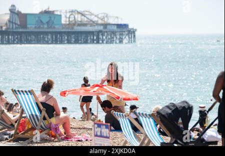 Brighton Großbritannien 19. Juli 2024 - Menschenmassen genießen die heiße Sonne am Brighton Beach mit Temperaturen, die in einigen Teilen des Südostens 30 Grad erreichen werden: Credit Simon Dack / Alamy Live News Stockfoto