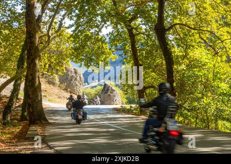 Griechenland. Sonniger Sommertag im Schatten der Bäume. Gruppe von Motorradfahrern auf einer kurvenreichen Bergstraße Stockfoto
