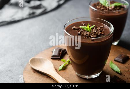 Schokoladen-Kakaopudding, Mousse in Glasbecher auf rustikalem Tisch, Supangle Stockfoto