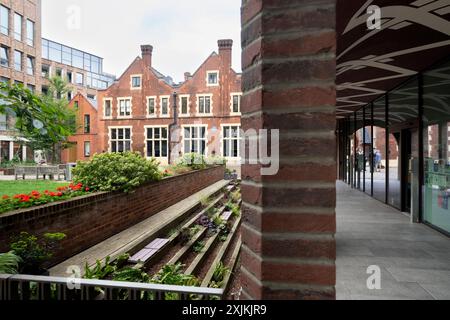 Blick auf die Toynbee Hall, ein historisches Gebäude im Londoner East End, mit Schwerpunkt auf dem Landschaftsgarten und dem modernen Fußweg Stockfoto