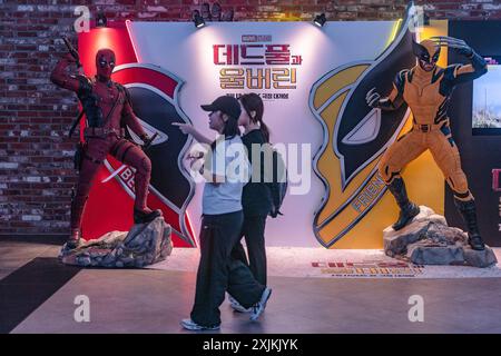 Seoul, Südkorea. Juli 2024. Frauen gehen an einer Plakatwand des Marvel Studios-Films „Deadpool & Wolverine“ in Seoul vorbei, der am 24. Juli in Südkorea veröffentlicht wird. Deadpool & Wolverine erscheint in Südkorea Credit: SOPA Images Limited/Alamy Live News Stockfoto