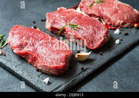 Rohes Rindersteak auf Steinbrett mit Thymian und Paprika, Metzgerkonzept Stockfoto