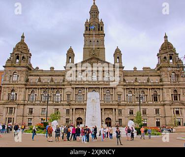 Glasgow, Schottland, Großbritannien. 19. Juli 2024: Touristen genießen die Spaziergänge auf dem george Square für ein Stolz-Wochenende, während Touristen und Einheimische den angrenzenden Markt in der Handelsstadt genießen und sich mit dem ikonischen Verkehrskegel, dem Symbol der Stadt, mit einer Vorhersage des nassen Wetters, in den Spaß einmischen. Credit Gerard Ferry /Alamy Live News Stockfoto