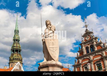 Eine Statue von Rigas Schutzpatron St. Roland steht zwischen dem Haus der Mitesser und dem Rathaus Stockfoto