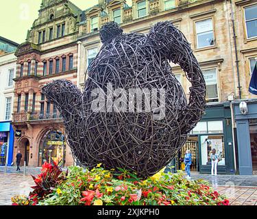 Glasgow, Schottland, Großbritannien. 19. Juli 2024: Korbskulpturen auf dem george Square eines Teekannen-Stolz-Wochenendes, während Touristen und Einheimische den angrenzenden Markt in der Handelsstadt genießen und sich mit dem ikonischen Verkehrskegel-Hut, dem Symbol der Stadt, mit einer Vorhersage des nassen Wetters, am Spaß beteiligen. Credit Gerard Ferry /Alamy Live News Stockfoto