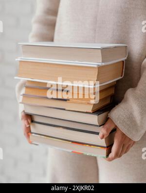 Schließen Sie Hände, die Bücher stapeln Stockfoto