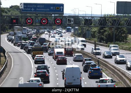 Bristol, Großbritannien. Juli 2024. Die Aussicht auf ein sonniges Juli-Wochenende verursacht Verkehrsstaus auf der M5, abgebildet ist der Stau zwischen den Anschlussstellen 15/16 und 17. Aufgrund des Verkehrsaufkommens in Richtung Süden in Richtung Devon und Cornwall gibt es verwaltete Geschwindigkeitsbeschränkungen auf der Autobahn. Highways England meldet Geschwindigkeiten in den tiefen 20ern Quelle: JMF News/Alamy Live News Stockfoto