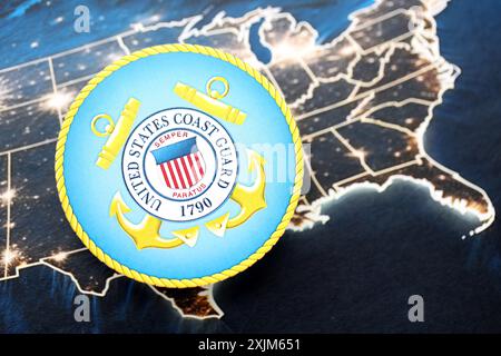 KIEW, UKRAINE - 26. JUNI 2024 Wappen der US-Küstenwache auf Papierkarte der Vereinigten Staaten von Amerika Stockfoto