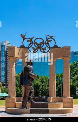 „Gateway of Dreams“-Wahrzeichen im Centennial Olympic Park, Atlanta, Georgia, USA. Die Skulptur zeigt die ikonischen olympischen Ringe und die Person Stockfoto