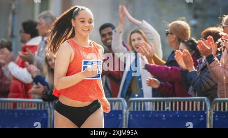 Porträt einer Frau, die in einem Park läuft und an einem Marathon teilnimmt. Starke sportliche Joggingerin, die andere Läufer mit Entschlossenheit für den ersten Platz in der Ziellinie fährt Stockfoto