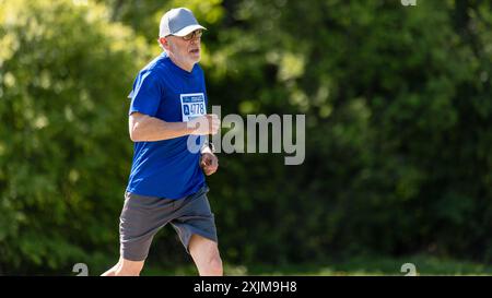 Porträt eines älteren männlichen Joggers, der in einem Park auf einem Health Trail läuft. Gesunder und fitter älterer Mann, der körperliche Aktivität genießt und in Form bleibt Stockfoto