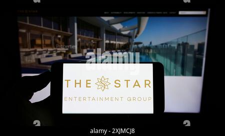 Stuttgart, Deutschland, 21.05.2022: Person, die ein Smartphone mit dem Logo des Unternehmens The Star Entertainment Group Limited auf dem Bildschirm vor der Website hält. Stockfoto