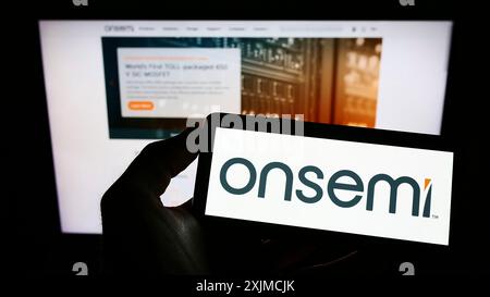 Stuttgart, Deutschland, 22.05.2022: Person, die ein Smartphone hält, mit Logo des US-amerikanischen Unternehmens AUF DER Semiconductor Corporation (onsemi) vor dem Bildschirm Stockfoto