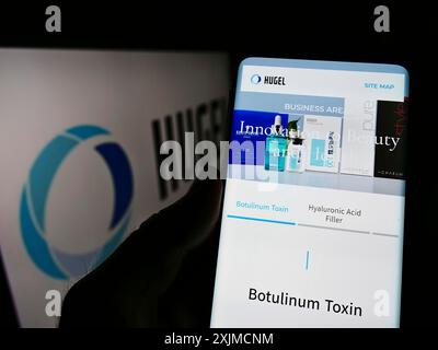 Stuttgart, Deutschland, 22.05.2022: Person, die ein Mobiltelefon hält, mit Website des südkoreanischen biopharmazeutischen Unternehmens Hugel Inc. Auf dem Bildschirm mit Logo. Fokus Stockfoto