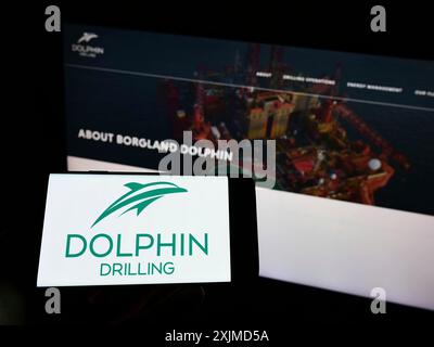 Stuttgart, Deutschland, 22.05.2022: Person, die ein Mobiltelefon mit dem Logo der Firma Dolphin Drilling Holdings Limited auf dem Bildschirm vor dem Geschäft hält Stockfoto