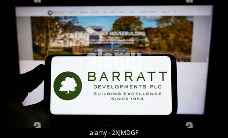 Stuttgart, Deutschland, 29.05.2022: Person, die ein Smartphone mit dem Logo der Immobilienfirma Barratt Developments plc auf dem Bildschirm vor der Website hält. Fokus Stockfoto