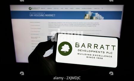 Stuttgart, Deutschland, 29.05.2022: Person mit Handy mit Logo der Immobiliengesellschaft Barratt Developments plc auf dem Bildschirm vor dem Geschäft Stockfoto