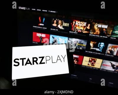 Stuttgart, Deutschland, 06.04.2022: Person, die ein Mobiltelefon mit dem Logo des Emirati-Streaming-Unternehmens Starzplay Arabia auf dem Bildschirm vor dem Geschäft hält Stockfoto