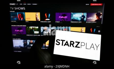 Stuttgart, Deutschland, 06.04.2022: Person, die ein Mobiltelefon mit dem Logo des emiratischen Streaming-Unternehmens Starzplay Arabia auf dem Bildschirm vor der Webseite hält. Stockfoto