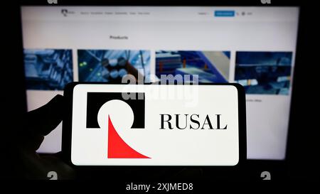 Stuttgart, Deutschland, 06.11.2022: Person, die ein Smartphone mit dem Logo der russischen Firma United Company RUSAL IPJSC auf dem Bildschirm vor der Website hält. Stockfoto