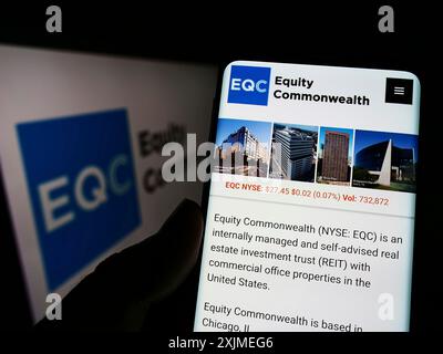 Stuttgart, Deutschland, 06-11-2022: Person, die ein Mobiltelefon hält, mit Website der Immobiliengesellschaft Equity Commonwealth (EQC) auf dem Bildschirm mit Logo. Konzentrieren Sie sich auf Stockfoto
