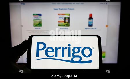 Stuttgart, Deutschland, 06.12.2022: Person, die ein Smartphone mit dem Logo des Pharmaherstellers Perrigo Company plc auf dem Bildschirm vor der Website hält. Stockfoto