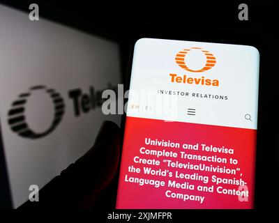 Stuttgart, Deutschland, 19.06.2022: Person, die ein Handy hält, mit Webseite des mexikanischen Medienunternehmens Grupo Televisa SAB vor dem Logo auf dem Bildschirm. Fokus Stockfoto