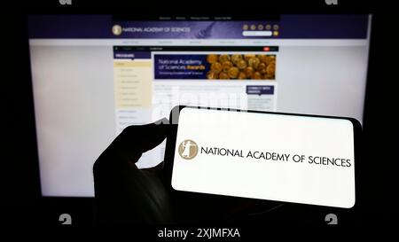 Stuttgart, 25.06.2022: Person mit Handy und Logo der Nationalen Akademie der Wissenschaften (NAS) auf dem Bildschirm vor der Webseite. Konzentrieren Sie sich auf Stockfoto