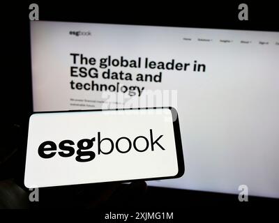 Stuttgart, 25.06.2022: Person mit Mobiltelefon mit Logo des britischen Nachhaltigkeitsdatenunternehmens ESG Book auf dem Bildschirm vor der Webseite. Stockfoto