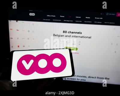Stuttgart, 25.06.2022: Person, die ein Mobiltelefon mit dem Logo des belgischen Telekommunikationsunternehmens Voo S.A. auf dem Bildschirm vor dem Geschäft hält Stockfoto