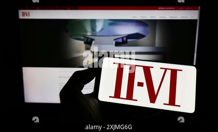 Stuttgart, Deutschland, 07.03.2022: Person, die ein Mobiltelefon hält, mit dem Logo des amerikanischen Halbleiterunternehmens II-VI auf dem Bildschirm vor der Kamera angebracht ist Stockfoto