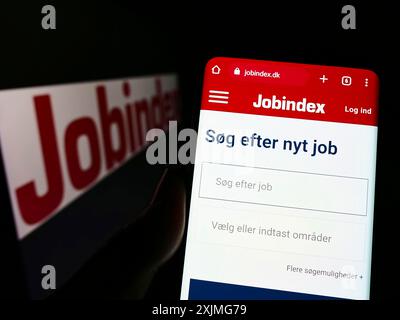 Stuttgart, Deutschland, 07.03.2022: Person, die ein Mobiltelefon hält, mit Website der dänischen Rekrutierungsplattform jobIndex auf dem Bildschirm mit Logo. Fokus Stockfoto