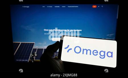 Stuttgart, Deutschland, 07.03.2022: Person mit Smartphone mit Logo des brasilianischen Erneuerbare-Energien-Unternehmens Omega Energia auf dem Bildschirm Stockfoto
