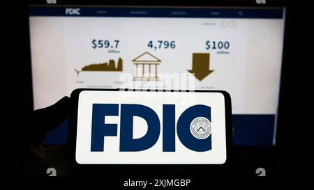 Stuttgart, Deutschland, 10.07.2022: Person, die ein Smartphone mit dem Logo der US Federal Deposit Insurance Corporation (FDIC) auf dem Bildschirm vor der Website hält. Stockfoto