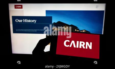 Stuttgart, Deutschland, 13.07.2022: Person, die ein Smartphone mit dem Logo des irischen Hausbauunternehmens Cairn Homes plc auf dem Bildschirm vor der Website hält. Stockfoto