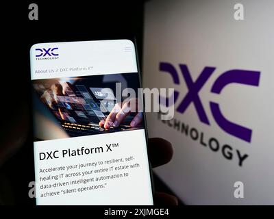 Stuttgart, Deutschland, 07.10.2022: Person, die ein Smartphone hält, mit Webseite der US-amerikanischen IT-Beratungsfirma DXC Technology Company auf dem Bildschirm mit Logo. Konzentrieren Sie sich auf Stockfoto