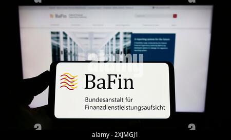 Stuttgart, 15.07.2022: Person mit Smartphone mit Logo der deutschen Finanzaufsichtsbehörde BaFin auf dem Bildschirm vor der Website. Stockfoto