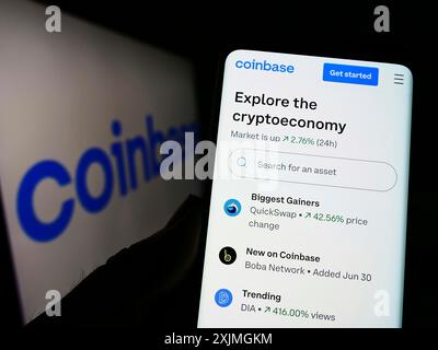 Stuttgart, 15.07.2022: Person, die ein Mobiltelefon hält, mit Webseite der US-amerikanischen Kryptobörse Coinbase Global Inc. Auf dem Bildschirm mit Logo. Fokus Stockfoto