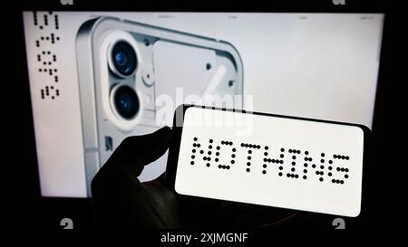 Stuttgart, 16.07.2022: Person, die ein Mobiltelefon mit dem Logo des britischen Unternehmens Nothing Technologies Limited auf dem Bildschirm vor dem Geschäft hält Stockfoto