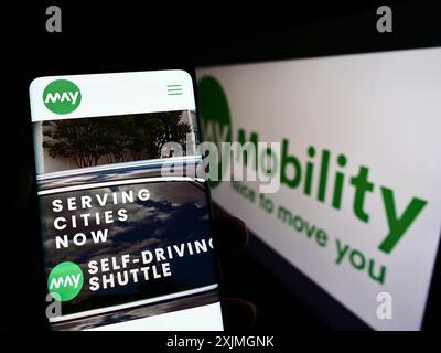 Stuttgart, 16.07.2022: Person, die ein Mobiltelefon hält, mit Webseite des US-amerikanischen Selbstfahrers May Mobility Inc. Auf dem Bildschirm vor dem Logo. Fokus Stockfoto