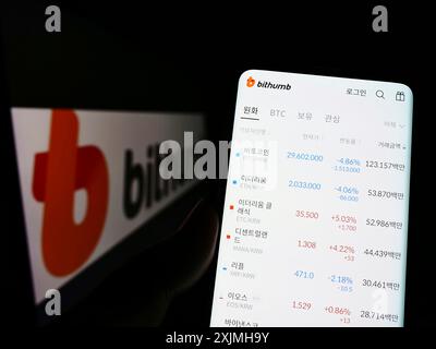 Stuttgart, 23.07.2022: Person, die ein Handy hält, mit Website der südkoreanischen Kryptowährungsbörse Bithumb auf dem Bildschirm mit Logo. Konzentrieren Sie sich auf Stockfoto