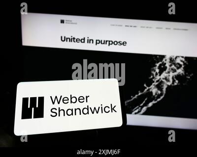 Stuttgart, Deutschland, 07-30-2022: Person, die ein Mobiltelefon mit dem Logo des Marketing-Kommunikationsunternehmens Weber Shandwick auf dem Bildschirm vor der Webseite hält. Stockfoto