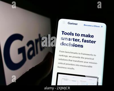 Stuttgart, Deutschland, 07-30-2022: Person, die ein Mobiltelefon hält, mit Webseite des US-Forschungsunternehmens Gartner Inc. Auf dem Bildschirm vor dem Geschäftslogo. Fokus Stockfoto
